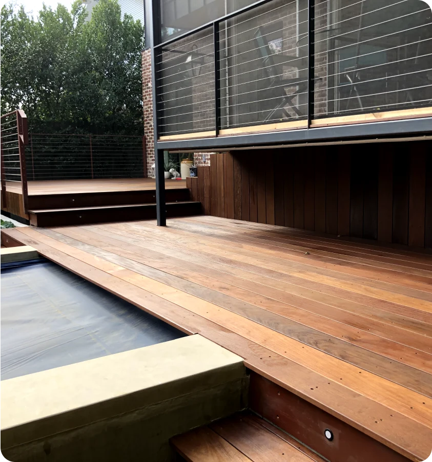 Custom-built wooden deck made of dark wood, created by J&L Hardscapes.