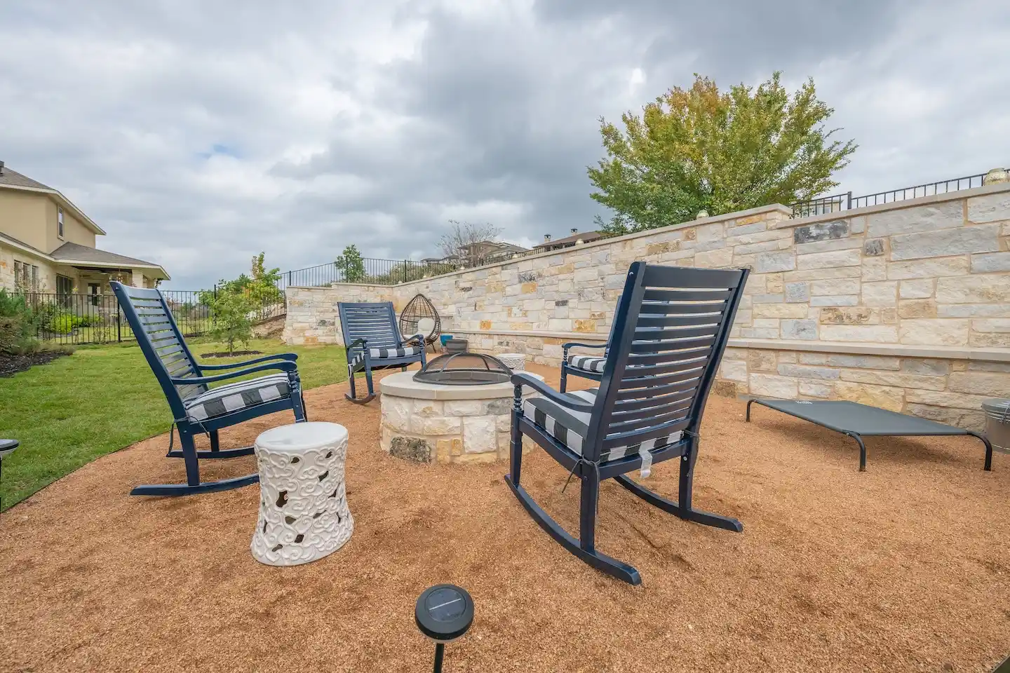 Tiered stone retaining wall holding back a sloped residential backyard 
